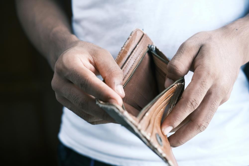 Get out of debt man looking in his wallet that is empty realizing he is in debt