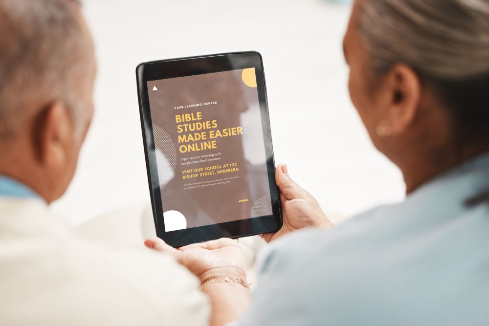 man and woman viewing online bible study at a school on their tablet as an example of passive income